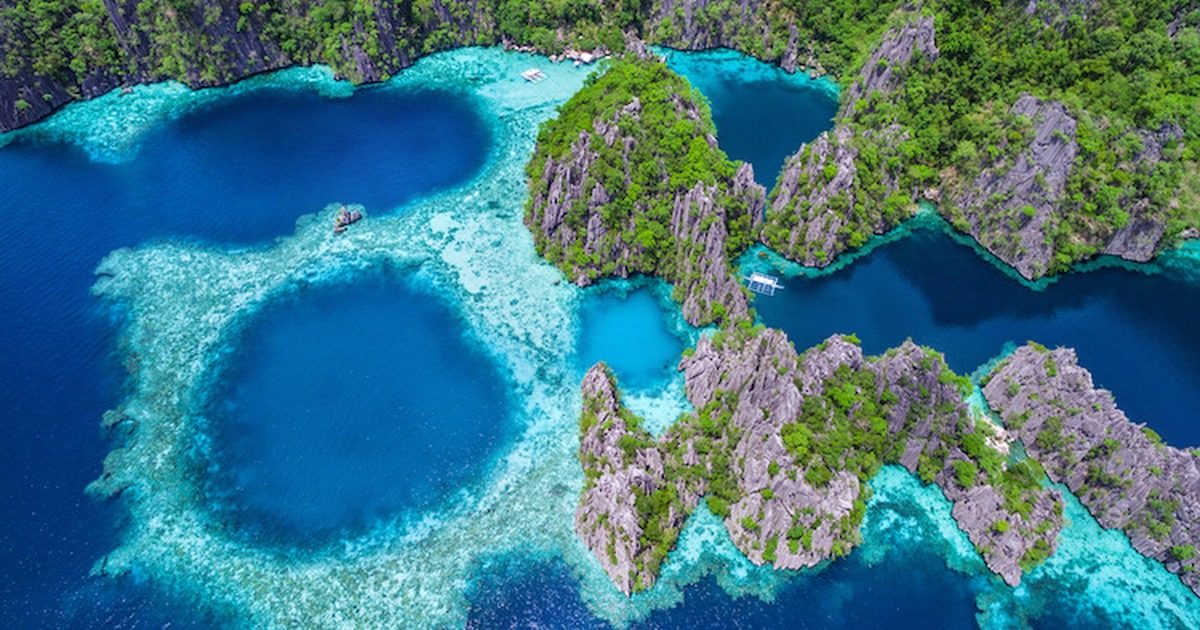 Vue aérienne de lagons profonds encerclés de reliefs karstiques à Palawan