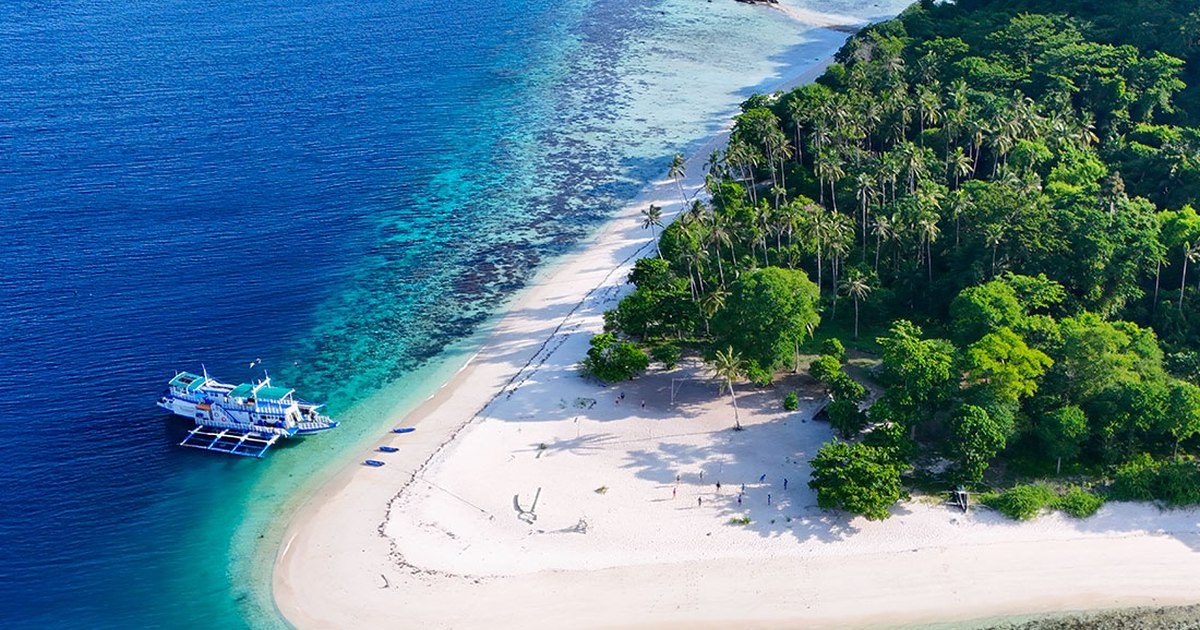 Plage de sable blanc vue du ciel à Palawan, bangka posée à la pointe de l'île