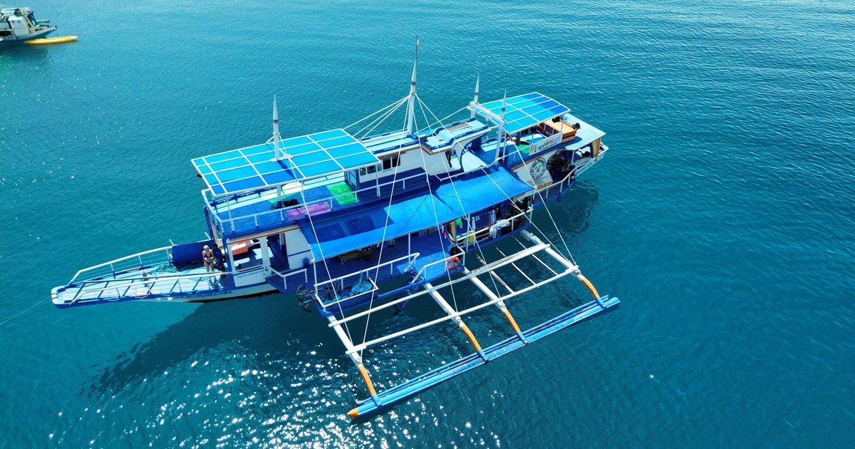 Grande bangka de croisière à l'ancre en eau turquoise, sur la route maritime El Nido — Coron