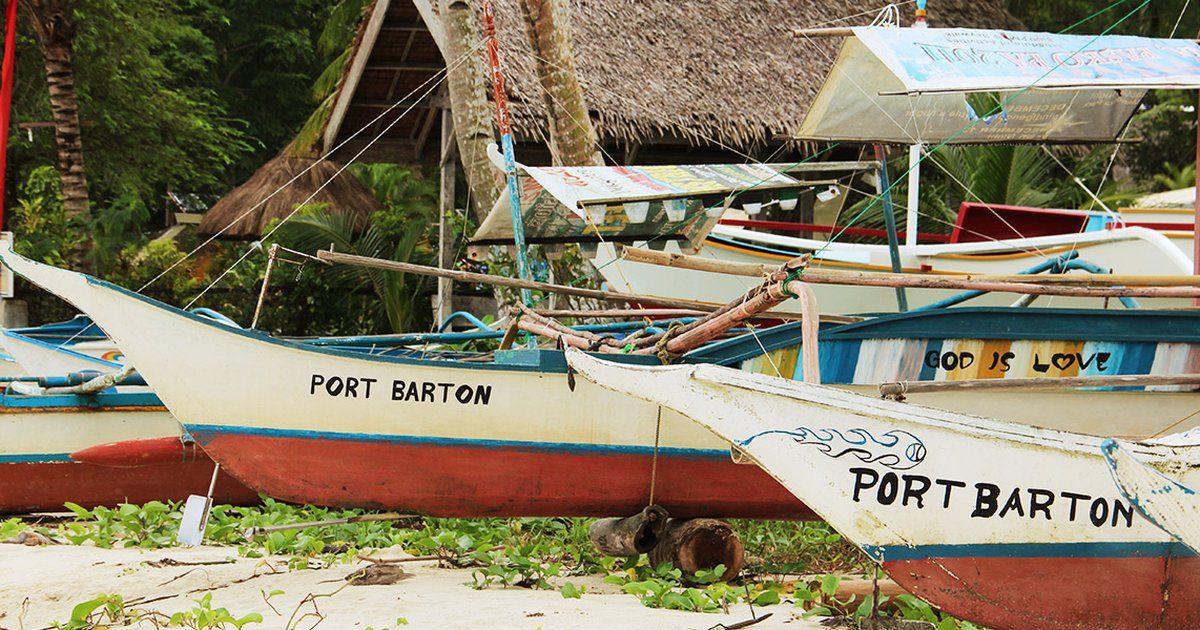 Bangkas peints portant le nom de Port Barton, tirés au sec sous les arbres